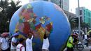 Replika bola dunia berukuran besar digelindingkan di sekitar kawasan Bundaran HI, Jakarta, Minggu (16/9). Acara ini bagian dari peringatan Hari Ozon Sedunia 2018 dengan tema Keep Cool and Carry on! The Montreal Protocol. (Liputan6.com/Helmi Fithriansyah)