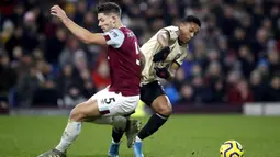 Pemain Manchester United Anthony Martial (kanan) berebut bola dengan pemain Burnley James Tarkowski pada pertandingan Liga Inggris di Turf Moor, Burnley, Inggris, Sabtu (28/12/2019). MU menang 2-0 dan melonjak ke posisi lima klasemen. (Martin Rickett/PA via AP)