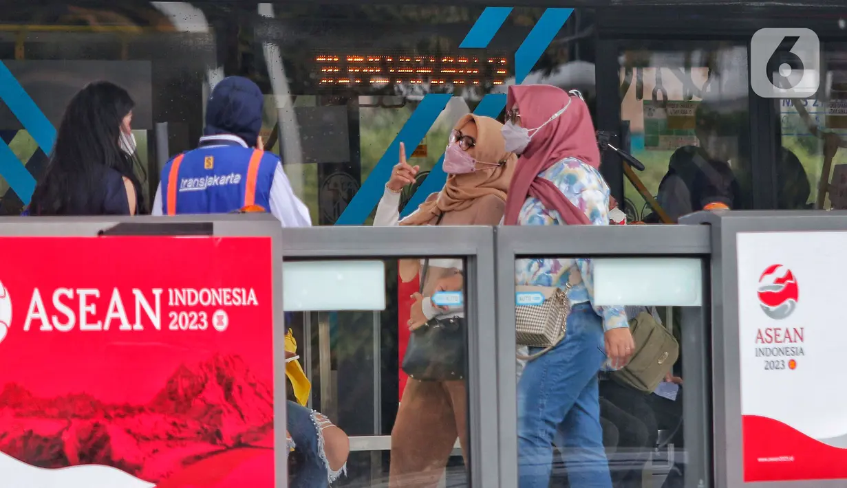 Penumpang berbincang di halte saat bus Transjakarta melintas di Jalan Sudirman, Jakarta, Selasa (31/1/2023). Kepala Dishub DKI Jakarta Syafrin Liputo mengatakan pihaknya masih melakukan evaluasi terhadap pemanfaatan tarif integrasi yang sekarang sudah dijalankan. (Liputan6.com/Angga Yuniar)