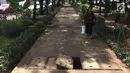 Pejalan kaki melintasi trotoar yang rusak dan berlubang di Jalan Kyai Tapa, Jakarta, Kamis (24/1). Banyaknya lubang akibat kerusakan penutup saluran air tersebut membahayakan pejalan kaki. (Liputan6.com/Immanuel Antonius)