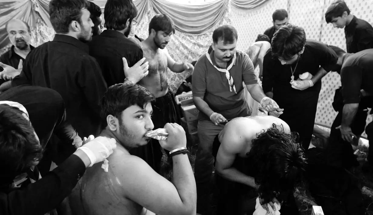 Petugas medis mengobati peserta perayaan perayaan Hari Asyura di Islamabad, Pakistan, Selasa (11/10). Melukai diri di Hari Asyura bagi kaum Syiah adalah bentuk ibadah untuk mengenang kematian Imam Husein. (REUTERS / Caren Firouz)