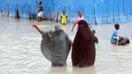 Wanita Somalia berjalan melewati air banjir saat hujan lebat di Mogadishu, Somalia, 20 November 2023. Banjir terburuk yang melanda Somalia dalam beberapa dekade telah menewaskan banyak orang dan memaksa ribuan orang meninggalkan rumah mereka. (AP Photo/Farah Abdi Warsameh)