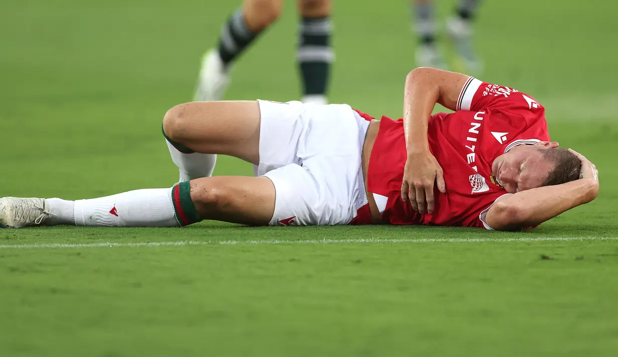 Pemain Wrexham, Paul Mullin terkapar sambil mengeram kesakitan setelah mengalami berbenturan dengan kiper Manchester United, Nathan Bishop pada laga uji coba pramusim di Snapdragon Stadium, San Diego, California, Rabu (25/07/2023) WIB. (AFP/Getty Images/Sean M. Haffey)