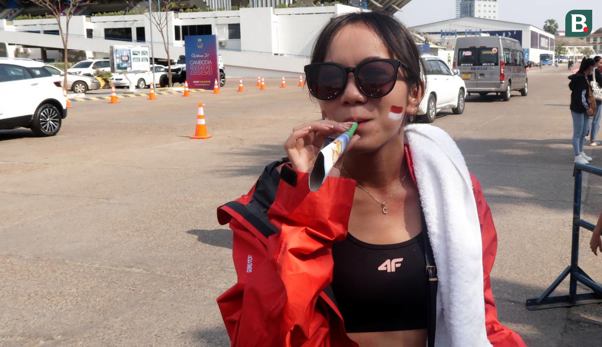 Seorang pendukung Indonesia meniup terompet saat menunggu laga kedua Grup A Sepak Bola SEA Games 2023 antara Timnas Indonesia melawan Timnas Myanmar di Olympic Stadium, Phnom Penh, Kamboja, Kamis (04/05/2023). Skuad asuhan Indra Sjafri tersebut berhasil menang dengan skor telak 5-0. (Bola.com/Gregah Nurikhsani)