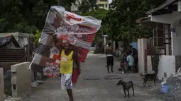 Seorang penduduk lingkungan El Fanguito membawa kasur untuk persiapan kedatangan Badai Ian, di Havana, Kuba, Senin, 26 September 2022. Badai Ian semakin kuat saat mendekati ujung barat Kuba di jalur untuk menghantam pantai barat Florida sebagai badai besar pada awal Rabu. (AP Photo/Ramon Espinosa)