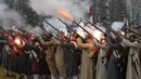 Sejumlah peserta berpakaian seperti tentara Rusia dan Prancis tahun 1812 melespaskan tembakan saat melakukan adegan pertempuran di Belarus (26/11). Perang tersebut antara pasukan tentara Napoleon melawan pasukan Rusia. (AP Photo/Sergei Grits)