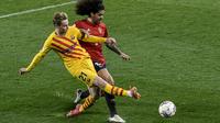 Gelandang Barcelona, Frenkie de Jong mencoba menembak bola dari kawalan pemain Osasuna, Aridane pada pertandingan lanjutan La Liga Spanyol di stadion El Sadar di Pamplona, Minggu (7/3/2021). Barcelona sukses menjaga jarak dua poin dengan pemuncak klsemen Atletico Madrid. (AP Photo/Alvaro Barrientos)