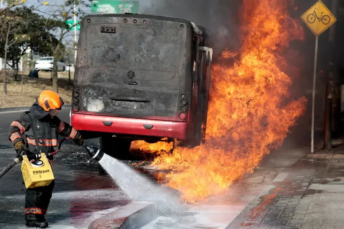Seorang petugas pemadam kebakaran memadamkan api yang membakar sebuah bus dalam insiden kerusuhan usai kematian bos kartel narkoba El Mencho di negara bagian Jalisco, Meksiko. (Dok. AFP/Ulises Ruiz)