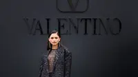 Zendaya mencuri perhatian saat hadir di show Valentino dengan outfit bernuansa hitam. Zendaya mengenakan gaun transparan dengan detail jaring-jaring yang dipadukan dengan short pants dan sequin blazer. (Valentino)