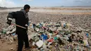 Pekerja membersihkan tumpukan sampah yang tersapu ke darat saat badai melanda kota pantai Zouq Mosbeh di utara Beirut, Lebanon, 22 Januari 2018. Hampir segala limbah termasuk plastik hingga pembalut wanita menumpuk di pantai itu. (AP/Hussein Malla)