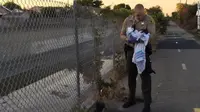 Petugas dari Departemen Sherif LA mengevakuasi bayi. (CNN)
