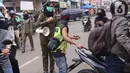 Petugas Satpol PP mengimbau warga untuk menggunakan masker dan menjaga jarak di Pasar Lama, Kota Tangerang, Banten, Sabtu (9/6/2020). Pemkot Tangerang melakukan penegasan pada PSBB tahap dua dengan menugaskan petugas di keramaian guna memutus rantai penyebaran COVID-19.  (Liputan6.com/Angga Yuniar)