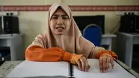 Kegiatan siswi di Malaysia menghafal Alquran yang telah disalin menggunakan huruf Braille (AFP)