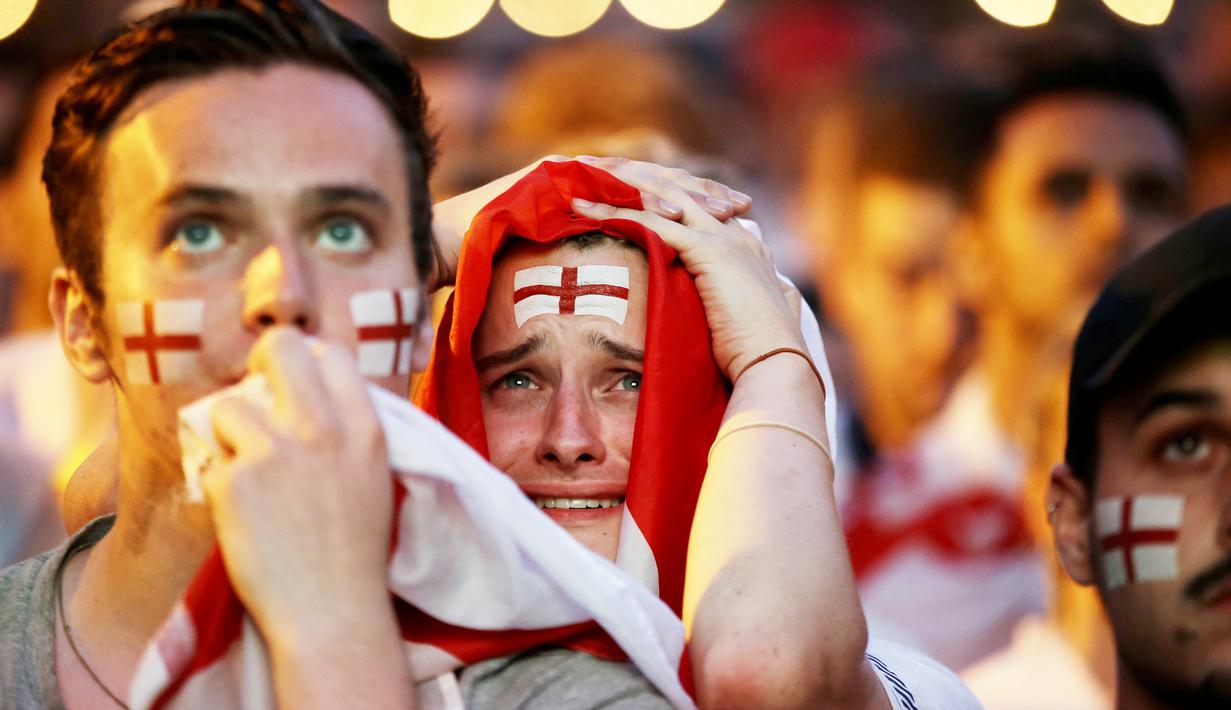 Sejumlah fans tampak kecewa saat timnas Inggris gagal melaju ke final Piala Dunia di Flat Iron Square, london, Rabu (11/7/2018). Kroasia menang 2-1 atas Inggris. (AP/Luca Bruno)