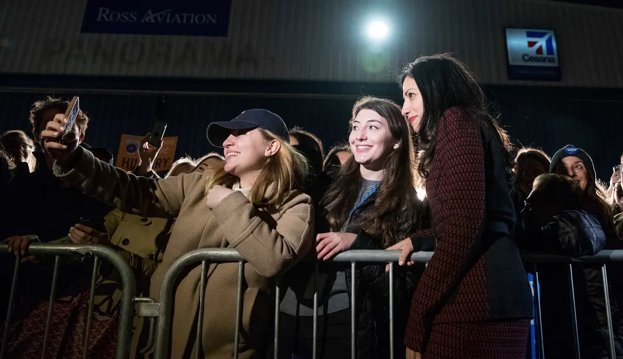 Ajudan Hillary Clinton, Huma Abedin berpose bersama pendukung Hillary Clinton saat tiba di Westchester County Airport di White Plains, New York, AS, Selasa (8/11). (AP Photo / Andrew Harnik)