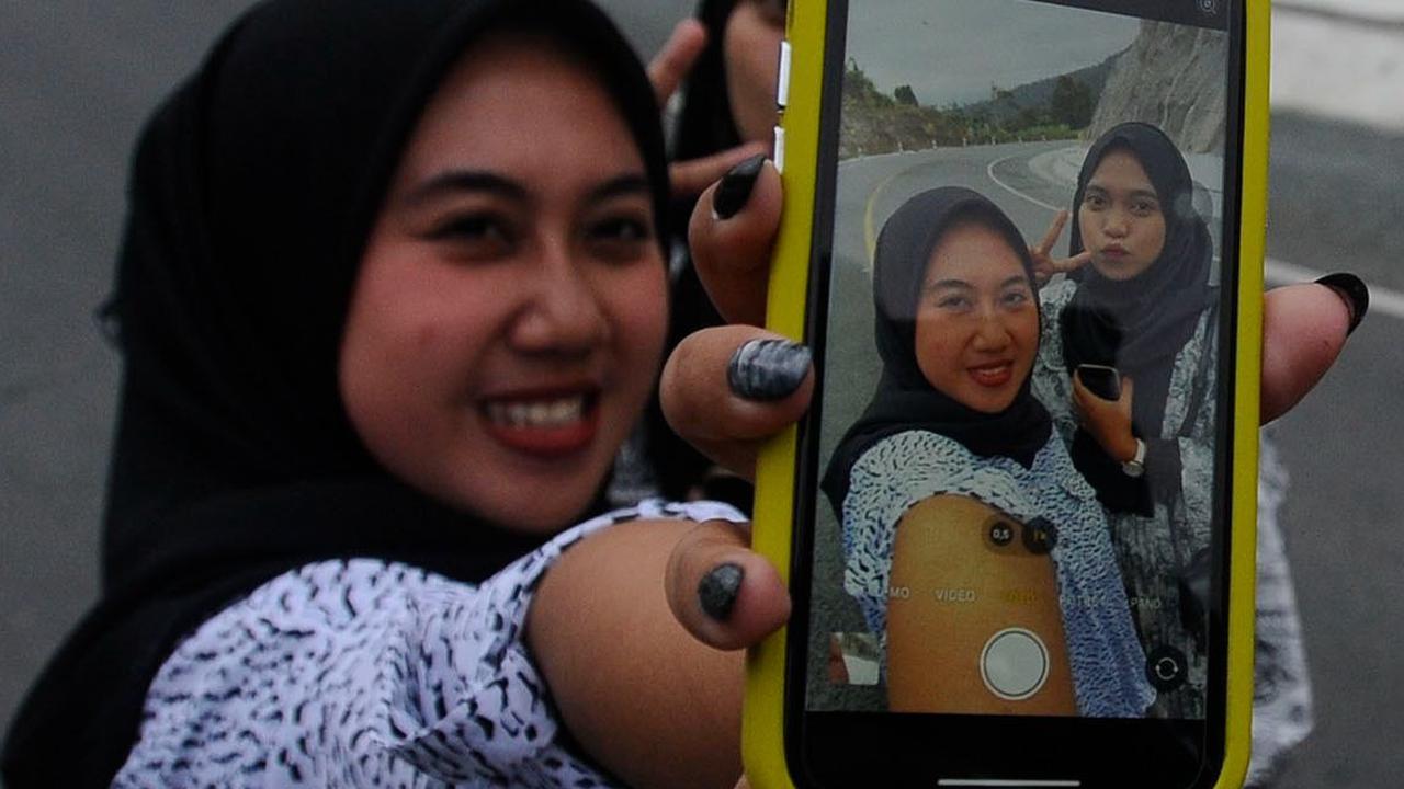 Ada yang berfoto selfie berdua dengan kamera ponselnya.