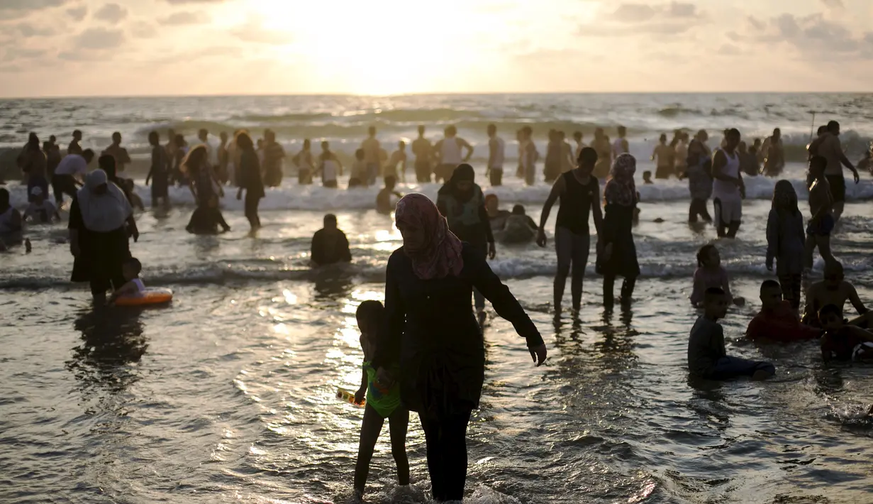 Sejumlah warga Palestina menikmati liburan di pantai Tel Aviv, Israel, Minggu (19/7/2015). Selama Idul Fitri, pemerintah Israel mengizinkan warga Palestina untuk berwisata di sepanjang garis pantai Mediterania. (REUTERS/Baz Ratner)