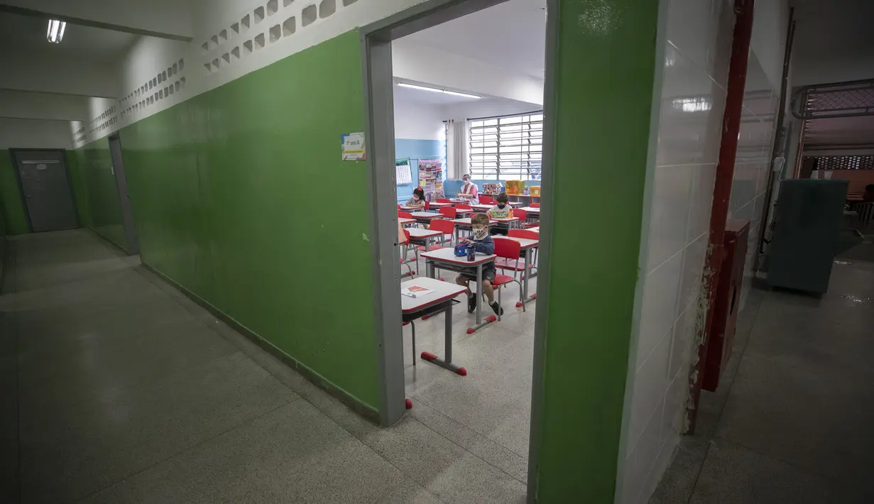 Sejumlah siswa mengenakan masker pada hari pertama kembali ke kelas tatap muka di tengah pandemi COVID-19 di sekolah umum Raul Antonio Fragoso di Sao Paulo, Brasil (8/2/2021). Sekolah tatap muka diizinkan dengan maksimal 35% siswanya. (AP Photo/Andre Penner)