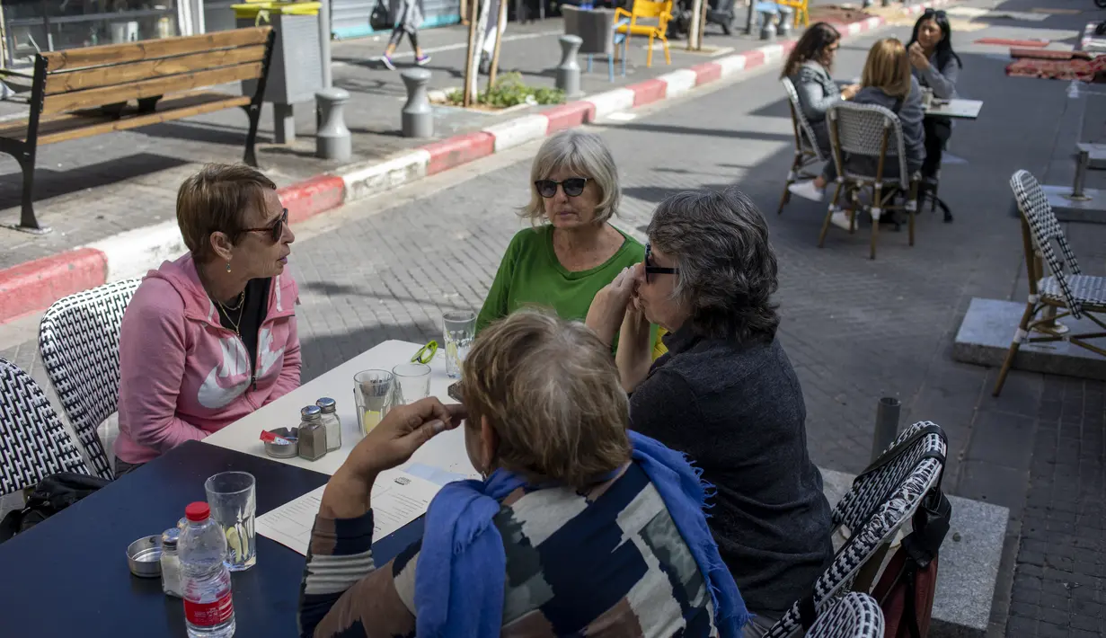 Orang-orang makan di restoran setelah pembatasan virus corona dilonggarkan di Tel Aviv, Minggu (7/3/2021). Israel membuka kembali sebagian besar ekonominya sebagai bagian dari fase terakhir pencabutan kebijakan lockdown yang berlaku sejak September tahun lalu. (AP Photo/Ariel Schalit)