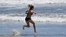 Seorang wanita berlari di Pantai Venice, Los Angeles (13/5/2020). Los Angeles County membuka kembali pantai-pantainya pada Rabu dalam pelonggaran terbaru pembatasan coronavirus yang telah menutup sebagian besar ruang publik dan bisnis California selama hampir dua bulan. (AP/Mark J. Terrill)