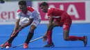 Asrul Alam dari Indonesia (kiri) memukul bola melawan pemain Singapura Ramanan Thulasiram, selama pertandingan hoki putradi Pesta Olahraga Asia Tenggara ke-32 di Phnom Penh, Kamboja, Selasa (9/5/2023). (AP Photo/Tatan Syuflana)