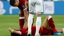 Pemain Liverpool Mohamed Salah kesakitan usai dicederai oleh bek Real Madrid Sergio Ramos dalam pertandingan final Liga Champions di Stadion NSK Olimpiyskiy, Ukraina (26/5). Dalam pertandingan ini Liverpool kalah 1-3. (AP/Pavel Golovkin)