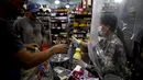 Kasir supermarket melakukan social distancing atau menjaga jarak dengan melayani pembeli lewat balik tirai palstik di Buenos Aires, Argentina, Senin (16/3/2020). Social distancing adalah cara terbaik untuk mencegah penyebaran virus corona COVID-19. (AP Photo/Natacha Pisarenko)