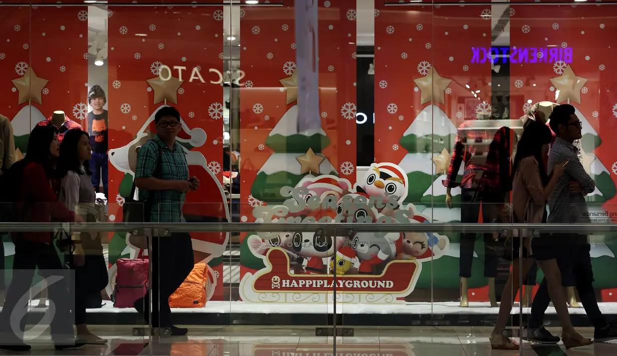  Pengunjung melintasi toko di Mal Central Park yang mendesain tokonya dengan ornamen Natal, Jakarta  Rabu (21/12). Jelang perayaan natal sejumlah mal di Jakarta mendekor mal bernuansa natal agar menjadi daya tarik pengunjung. (Liputan6.com/Johan Tallo)