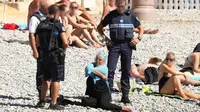 Foto polisi menjatuhkan denda pada perempuan yang mengenakan burkini memicu kontroversi di Prancis (CNN)