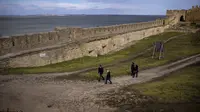 Orang-orang berjalan di dalam benteng Akkerman di sungai Dnester, di wilayah Odessa, Ukraina (19/2/2022). Benteng abad pertengahan "Akkerman", yang terletak di tepi muara Dniester dianggap sebagai salah satu kastil terbesar dan terpelihara dengan baik di Ukraina. (AP Photo/Emilio Morenatti)