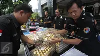 Dit Narkoba Polda Metro Jaya menata barang bukti hasil Operasi Bersinar Jaya 2016, Jakarta, Rabu (13/4). Petugas mengungkap peredaran narkoba internasional dengan mengamankan 36,43 kg shabu kristal yang dikemas kotak cokelat. (Liputan6.com/Gempur M Surya)