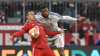 Pemain Liverpool, Georginio Wijnaldum berebut bola dengan  pemain Bayern Munchen Thiago Alcantara pada leg kedua babak 16 besar Liga Champions di Allianz Arena, Rabu (13/3). Liverpool menundukkan tuan rumah Bayern Munchen 3-1. (AP/Kerstin Joensson)