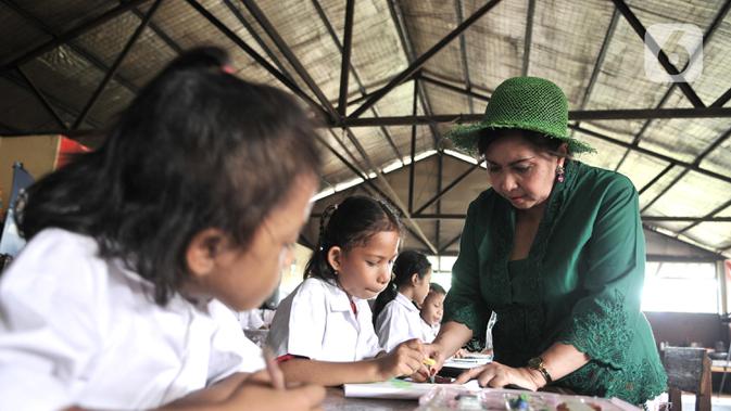 Sri Rossyati memberikan materi pengajaran kepada siswa Sekolah Darurat Kartini di kawasan Lodan, Jakarta Utara, Senin (25/11/2019). Sekolah Darurat Kartini didirikan pada tahun 1990 an oleh dua wanita kembar asal Yogyakarta, Sri Rossyati dan Sri Irianingsih. (merdeka.com/Iqbal Nugroho)