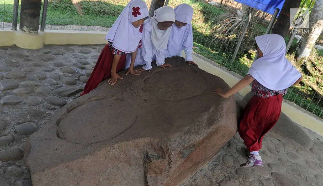 Murid SD melihat prasasti telapak kaki gajah di Prasasti Kebun Kopi, Ciaruteun Ilir, Bogor, Jawa Barat, Rabu (15/8). Kegiatan study tour ini menyambut HUT ke-73 RI sekaligus pengenalan sejarah bangsa Indonesia. (Merdeka.com/Arie Basuki)