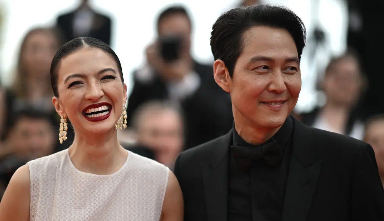Aktris Indonesia Raline Shah (kiri) bersama aktor dan sutradara Korea Selatan Lee Jung-Jae tiba untuk pemutaran film "Decision to Leave (Heojil Kyolshim)" selama Festival Film Cannes edisi ke-75 di Cannes, Prancis selatan, pada 23 Mei 2022. Terlihat Raline Shah berpose tersenyum sambil mengenakan gaun putih dengan Lee Jung Jae di sampingnya. (Photo by LOIC VENANCE / AFP)