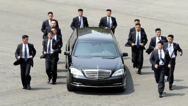'Paspampres' mengawal mobil yang ditumpangi pemimpin Korea Utara Kim Jong-un. (AFP/Korea Summit Press Pool)