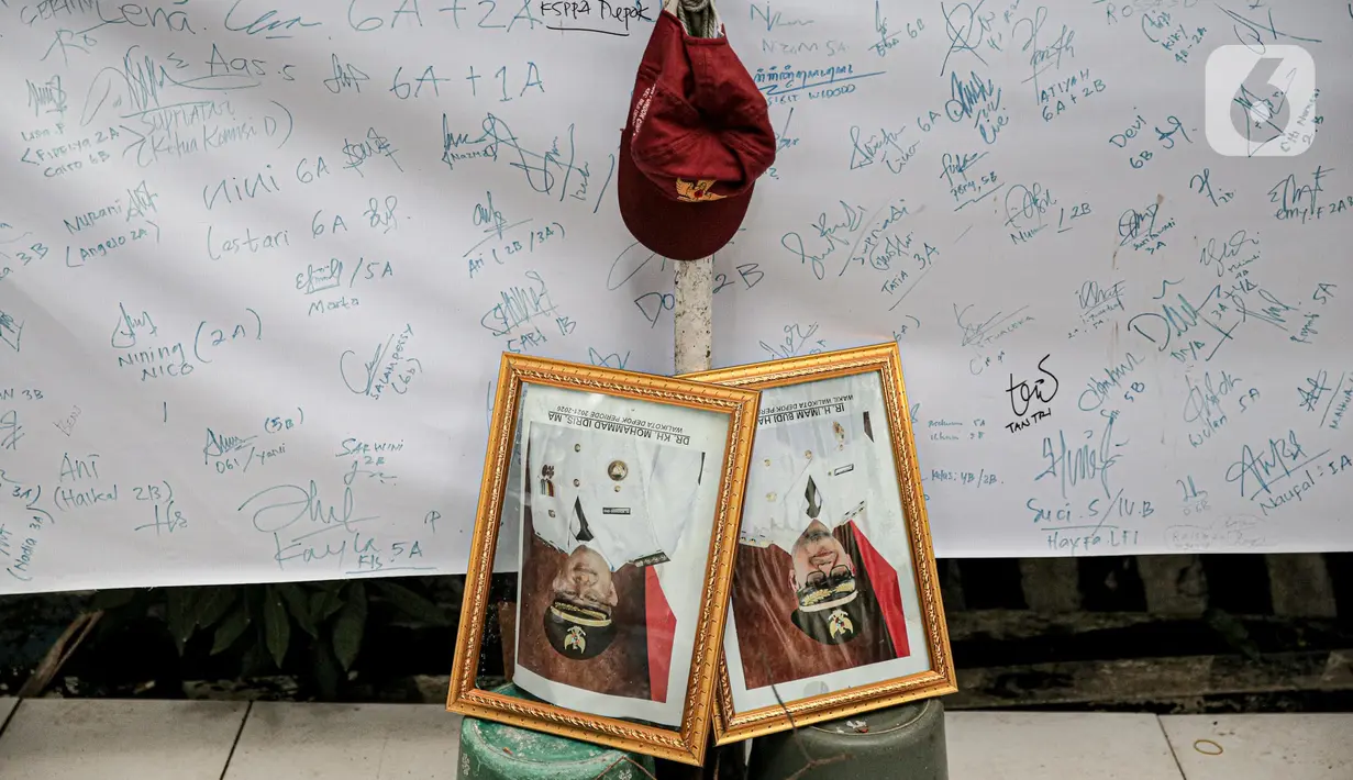 Bingkai foto Wali Kota Depok Muhammad Idris dan Wakil Wali Kota Depok Imam Budi Hartono ditempatkan di depan spanduk yang penuh dengan tanda tangan saat unjuk rasa sejumlah mahasiswa dari berbagai kampus di SDN Pondok Cina 1 Depok, Jawa Barat, Selasa (13/12/2022). Dalam aksinya, mereka menolak relokasi SDN Pondok Cina 1 yang lahannya akan digunakan untuk pembangunan masjid. (Liputan6.com/Faizal Fanani)