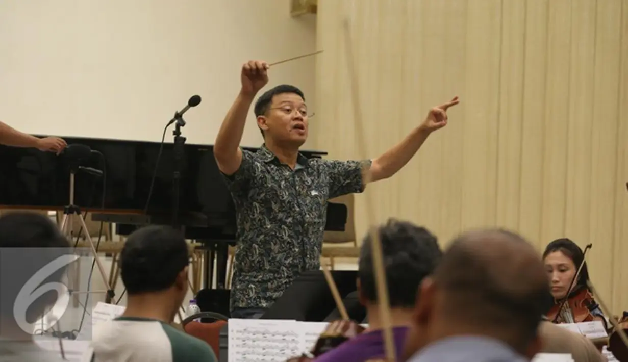 Konduktor Avip Priatna berlatih bersama Jakarta Concert Orchestra dan Batavia Madrigal Singers di Jakarta (8/11). Pertunjukan musik pilihan bertajuk Hymn of Praise akan digelar di Aula Simfonia Jakarta 12 Desember mendatang. (Liputan6.com/Fery Pradolo)