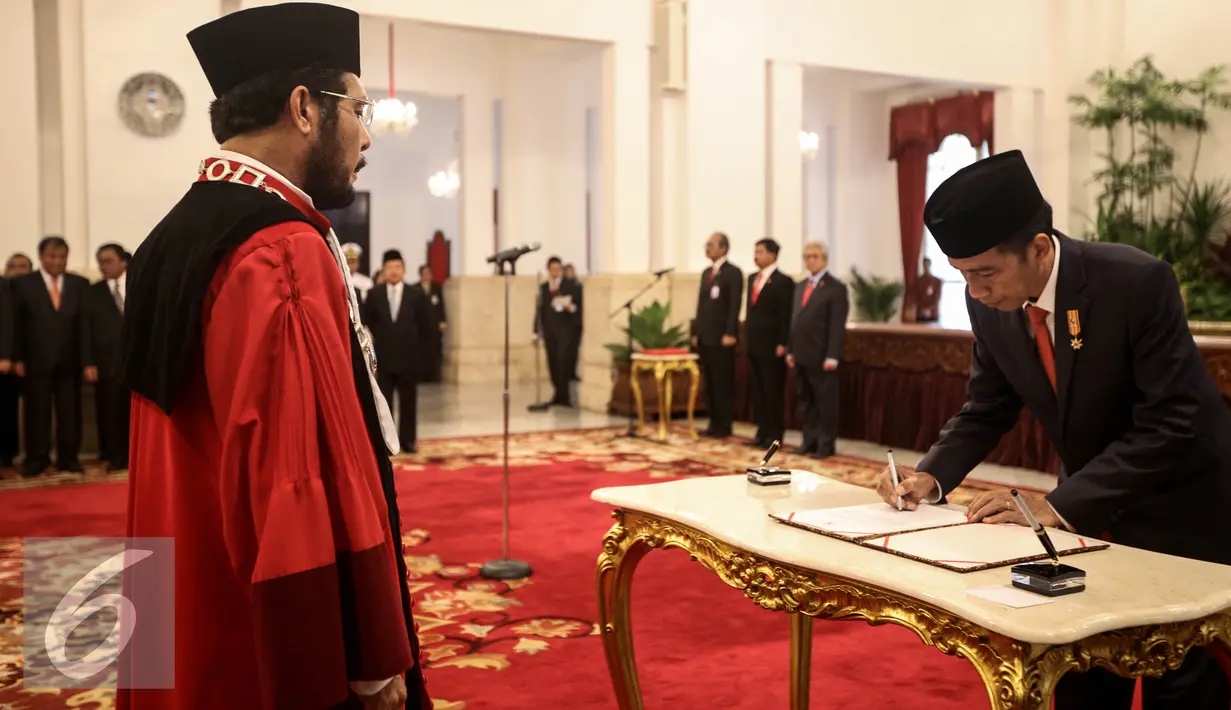 Presiden Jokowi menandatangani berita acara usai Wakil Ketua Mahkamah Konstitusi Anwar Usman menandatangani pengucapan sumpah sebagai Hakim Konstitusi di Istana Negara, Jakarta, Kamis (6/4). (Liputan6.com/Faizal Fanani)