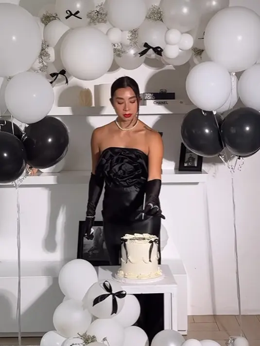 Ia tampil glamor mengenakan strapless dress dengan aksen mawar hitam besar di bagian dada [@jenniferbachdim]