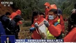 Pekerja darurat memasukkan perekam "kotak hitam" berwarna oranye ke dalam kantong plastik di lokasi kecelakaan pesawat Boeing 737-800 milik China Eastern Airlines  di Kabupaten Tengxian di Guangxi China selatan.