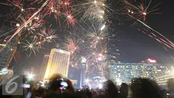 Kemeriahan kembang api menghiasi malam pergantian tahun di kawasan Bundaran HI, Jakarta, Sabtu (31/12). Antusiasme warga menyambut tahun 2017 diramaikan dengan pesta kembang api di sejumlah sudut Ibu Kota. (Liputan6.com/Immanuel Antonius)