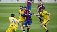 Bintang Barcelona Lionel Messi mencoba melewati para pemain Cadiz dalam lanjutan Liga Spanyol di Camp Nou, Minggu (21/2/2021). (AP Photo/Joan Monfort)