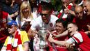 Lukas Podolski (tengah) berfoto bersama para suporter fanatik "The Gunners" sambil memegang trofi Piala FA saat parade kemenangan di London, Inggris, (18/5/2014). (REUTERS/Andrew Winning)