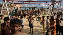 Anak-anak pengungsi Rohingya bermain ayunan di taman bermain di kamp pengungsi Thangkhali, dekat Cox's Bazar, Bangladesh, Kamis (9/8). (Ed JONES/AFP)