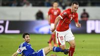 Penyerang Swiss, Josip Drmic (kanan) berusaha melewati adangan pemain San Marino, Marco Berardi, pada Kualifikasi Euro 2016 Grup E, di St Gallen (9/10/2015). Drmic absen pada putaran final Piala Eropa 2016.  (EPA/Gian Ehrenzeller)