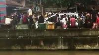 Para warga Kecamatan Ilir Timur (IT) I Palembang Sumsel, merusak dan mendorong mobil yang menabrak warga sekitar ke sungai (Liputan6.com / Nefri Inge)