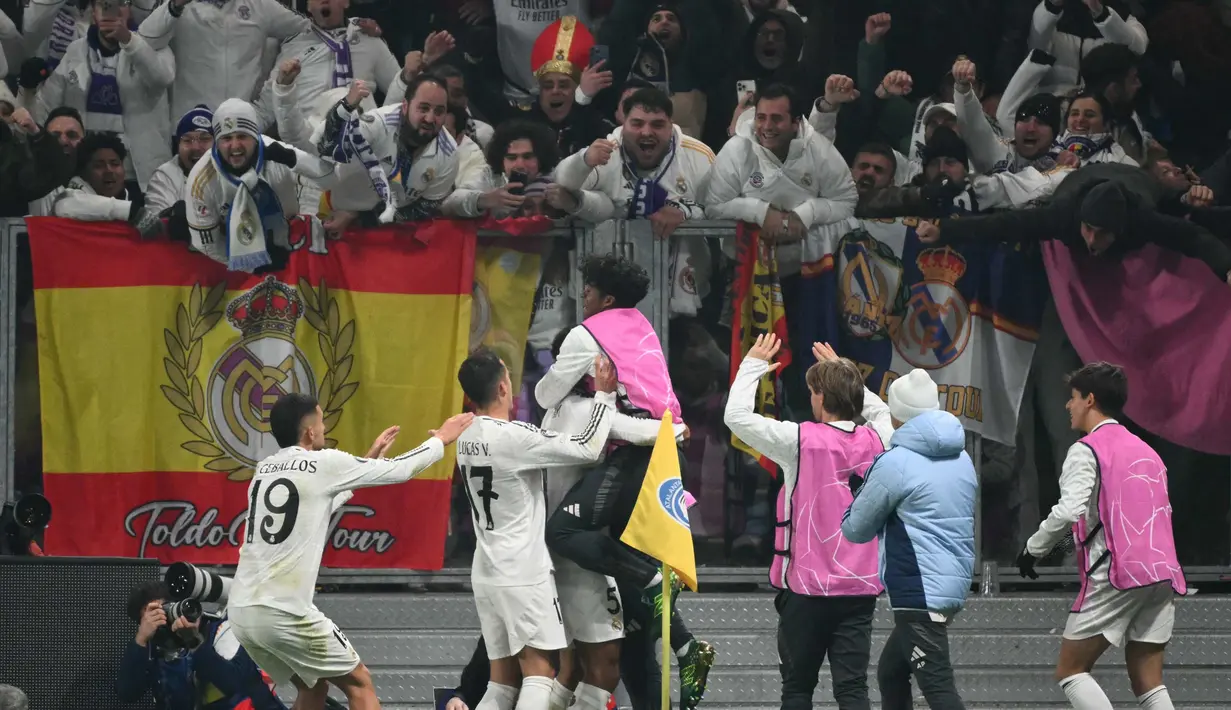 Pemain dan suporter Real Madrid merayakan gol yang dicetak Jude Bellingham pada pertandingan keenam Liga Champions 2024/2025 melawan Atalanta di Stadion Gewiss, Bergamo, pada Selasa 10 Desember 2024 waktu setempat atau Rabu 11 Desember 2024 dini hari Waktu Indonesia Barat. (Alberto PIZZOLI/AFP)