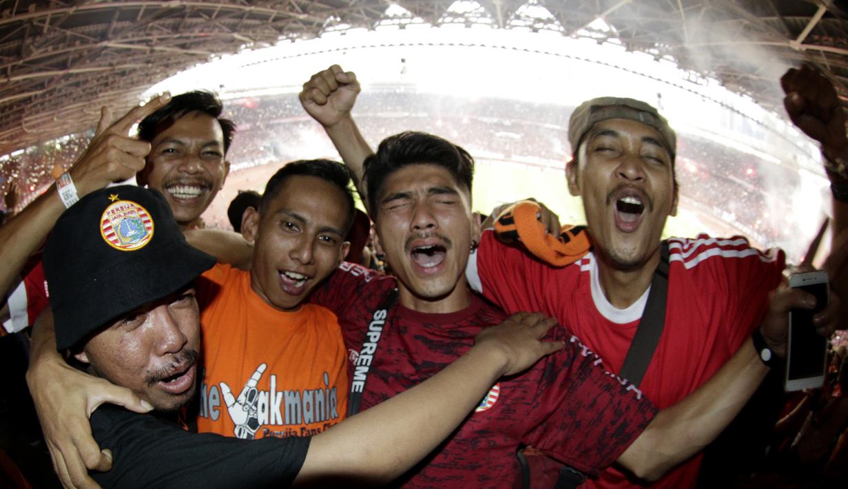 Suporter Persija Jakarta merayakan gelar juara Liga 1 di SUGBK, Jakarta, Minggu (09/12). Persija menang 2-1 atas Mitra Kukar. (Bola.com/M Iqbal Ichsan)