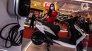 Model berpose dekat sepeda motor listrik pada pembukaan Indonesia Motorcycle Show (IMOS) 2022 di stan Yamaha, Jakarta Convention Center (JCC), Jakarta, Rabu (2/11/2022). Pameran ini diselenggarakan oleh Asosiasi Industri Sepedamotor Indonesia (AISI). (Liputan6.com/Johan Tallo)